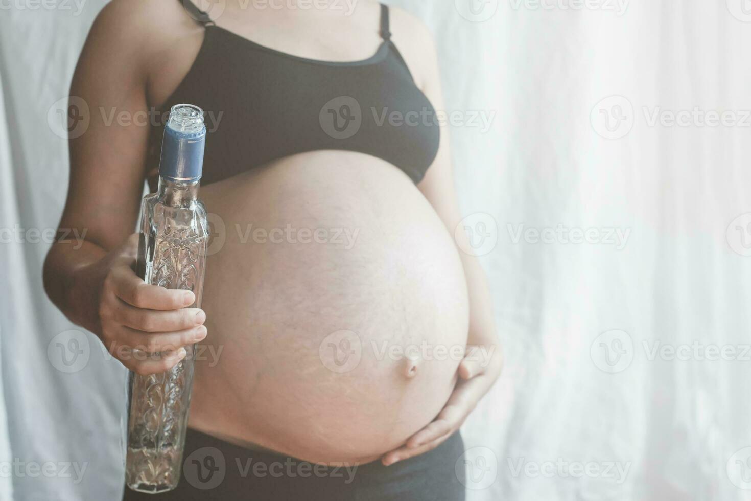 Pregnant woman holding vodka alcohol bottle 31164047 Stock Photo at