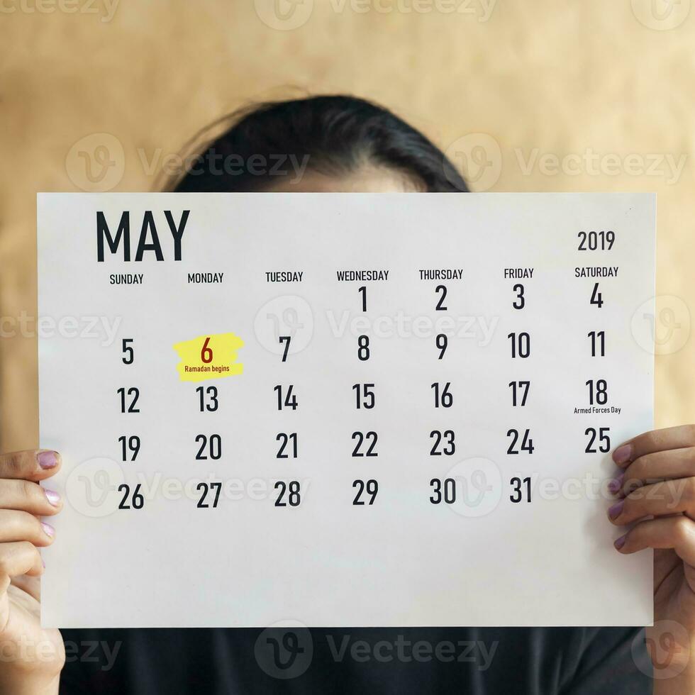 Woman holding Monthly calendar of May. 6th May 2019 marked as Ramadan beginning day photo