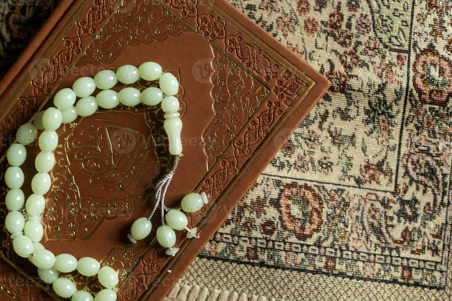 The Holy Quran with rosary and praying carpet. Image of The Holy Quran with rosary. Muslim Rosary Beads And Quran. Flat lay view photo