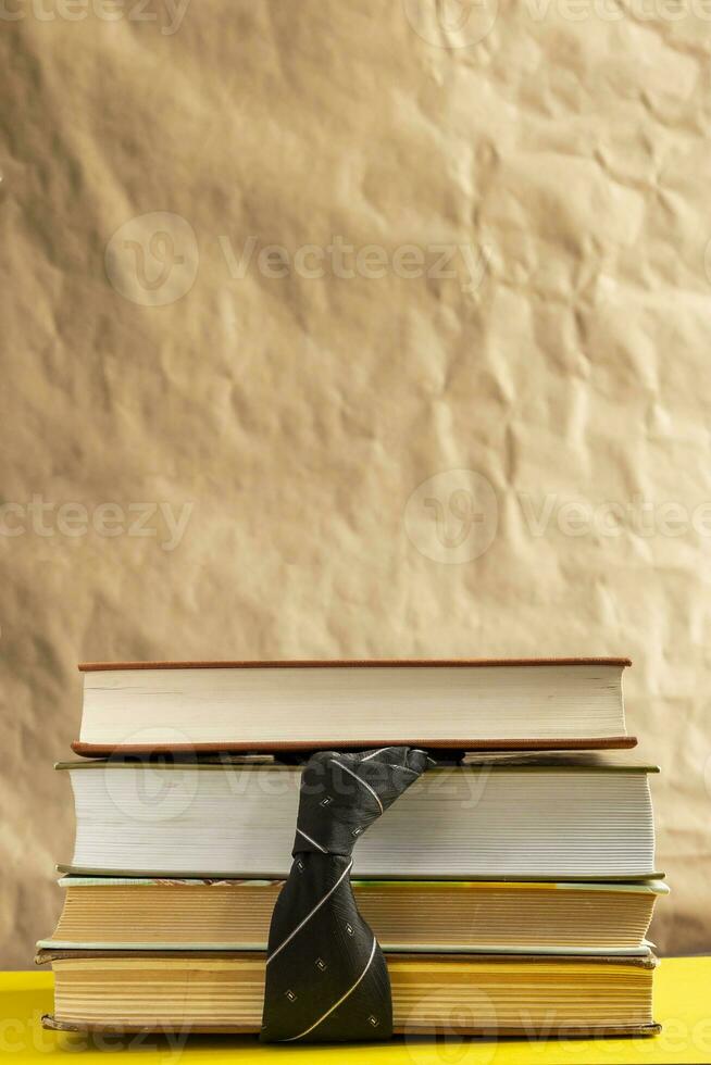 Back to school concept. Stack of books and a tie with a glasses photo