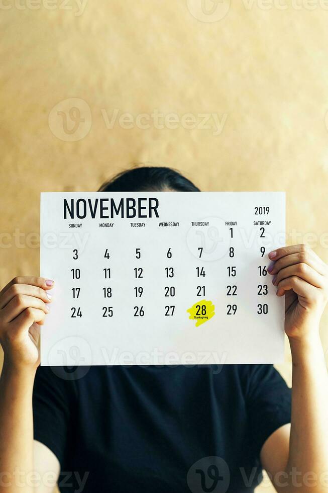 A woman holding Thanksgiving day marked at 2019 calendar photo