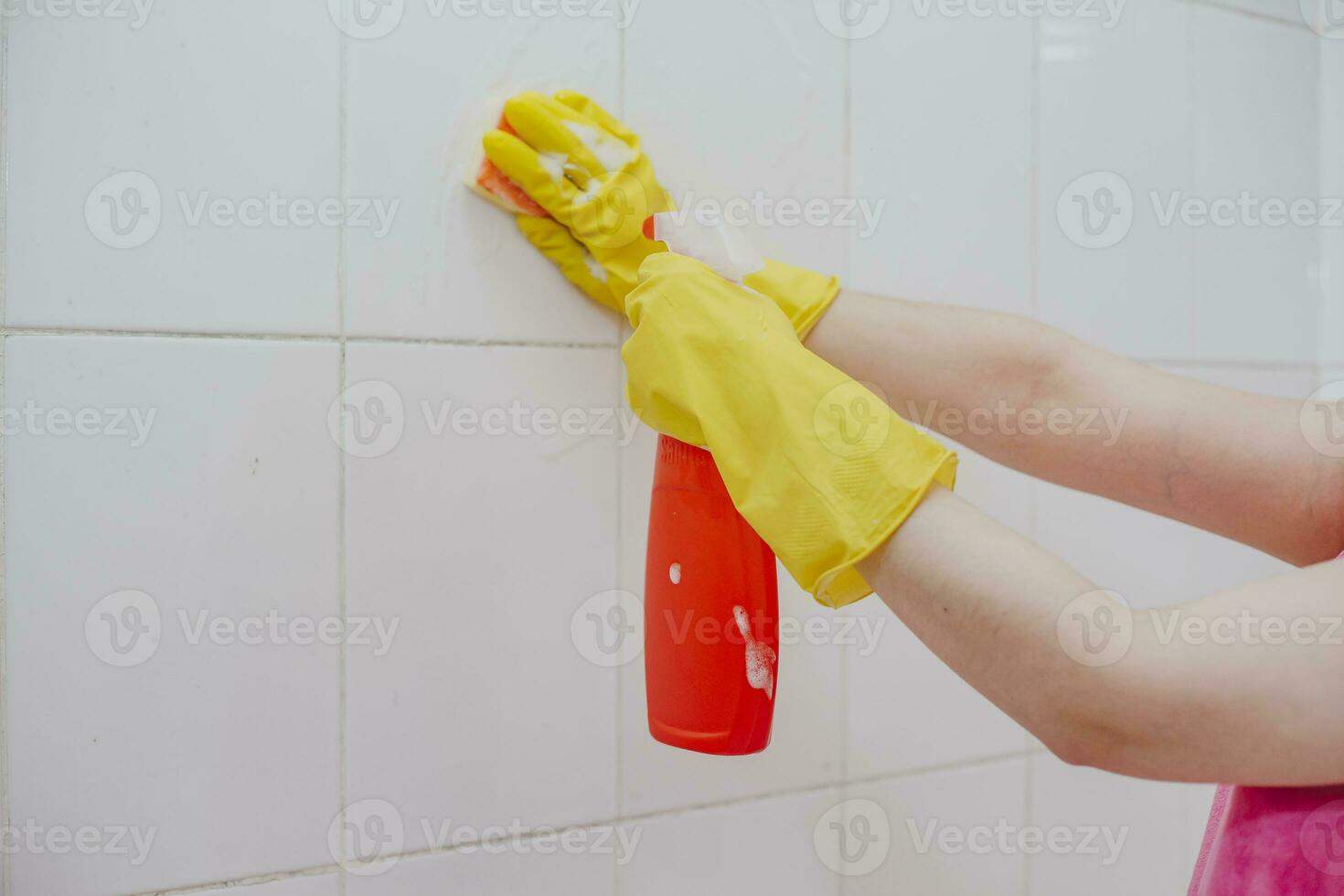 Cleaning bathroom tiles. Women washing bath walls. Housemaid cleaning up tiles of bath. Householding photo