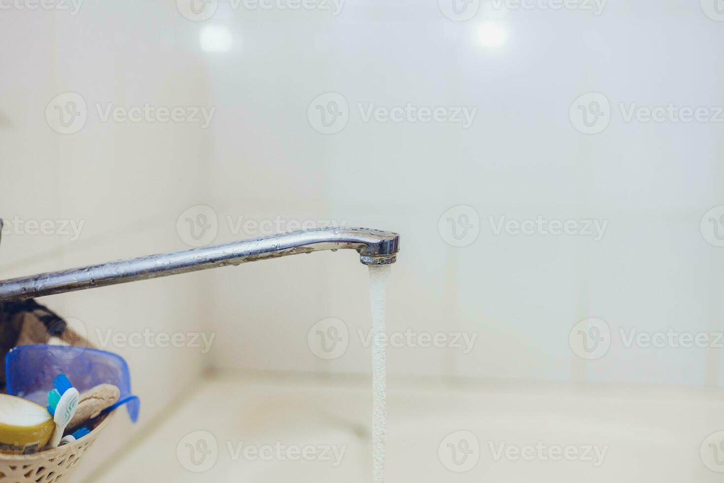 Bathroom. Open bath water tap with running water. photo