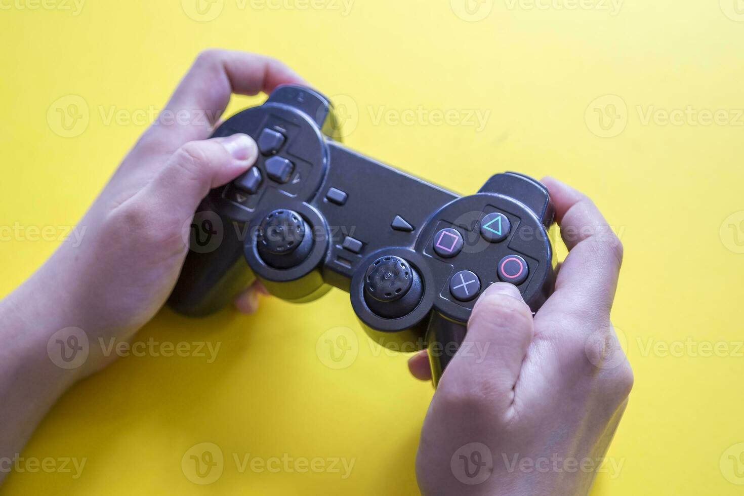 Gamer holding video games gaming controller on yellow photo