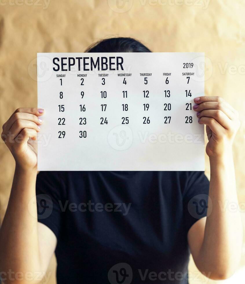 A woman holding simple September 2019 calendar photo