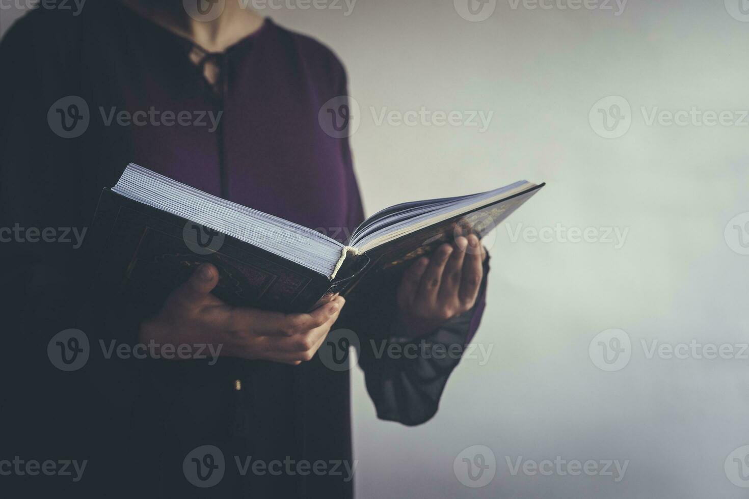 Praying young muslim woman. Middle eastern girl praying and reading the holy Quran. Muslim woman studying The Quran photo