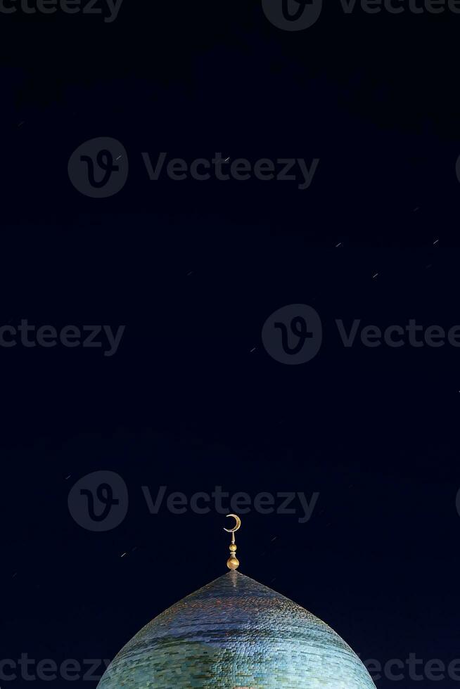 The golden crescent on the dome of the Mosque. Waxing moon - a symbol of Islam at the top of the temple at night sky with stars. Free space. For Ramadan and Eid background photo