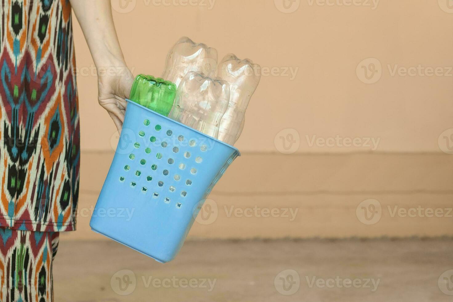Plastic pollution. Female collected plastic bottles and holding recycling bin. Free space photo