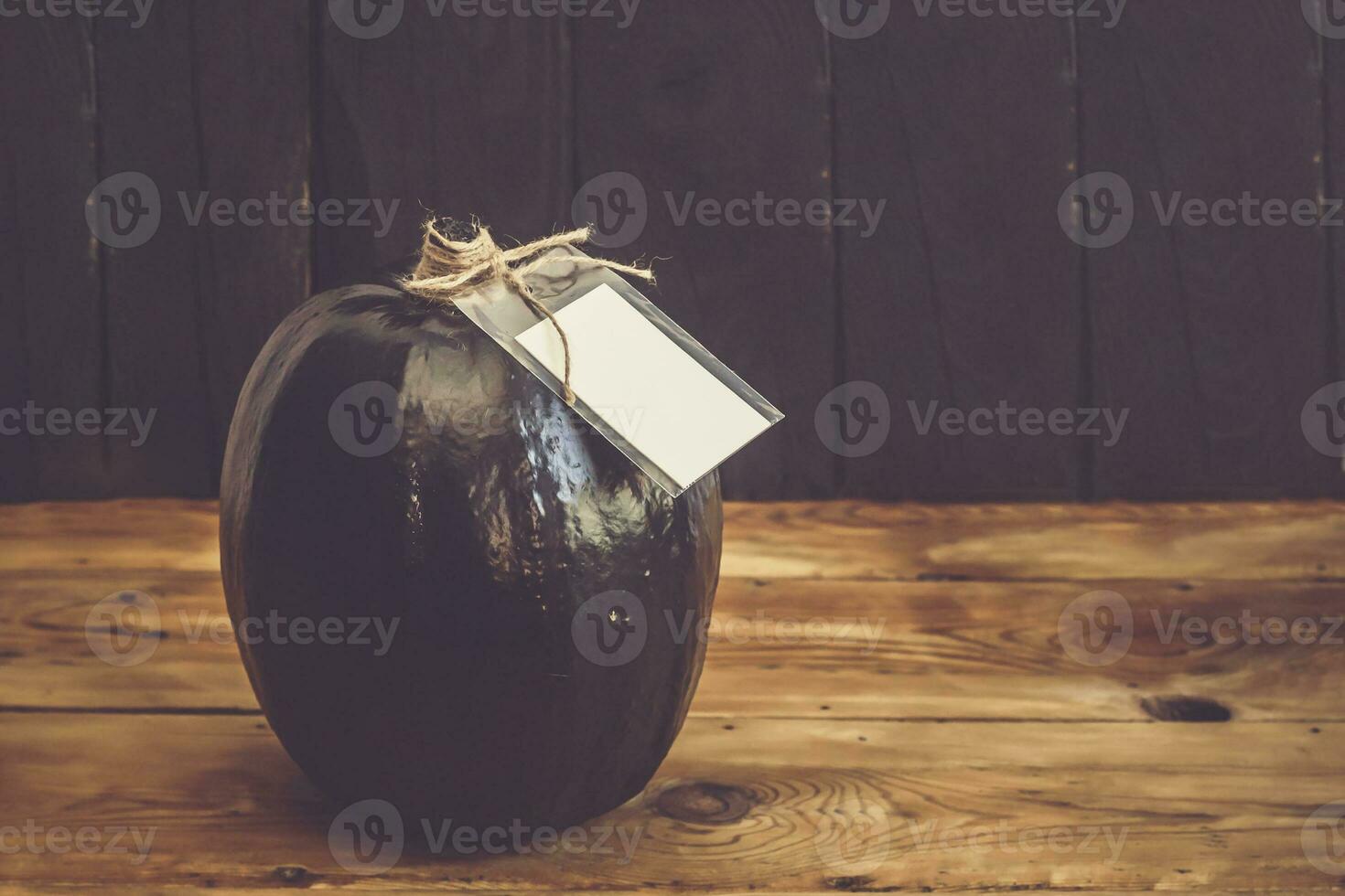 A big black pumpkin with an empty white paper tag photo