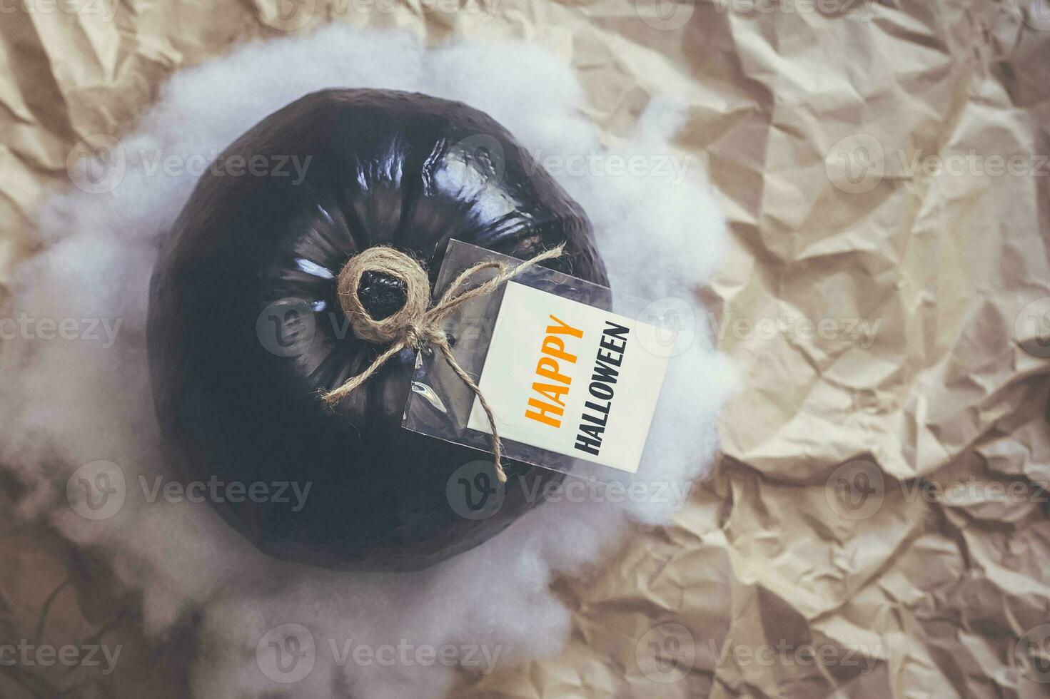 A big black pumpkin with an empty white paper tag photo