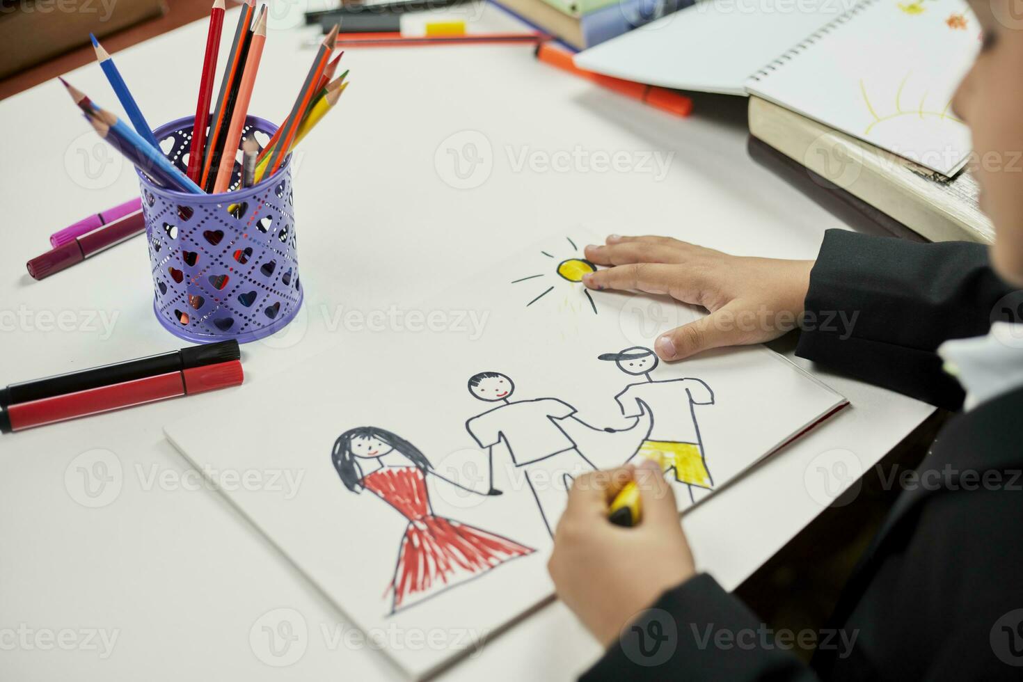 Family therapy. Schoolboy drawing family. Painting with colored marker photo