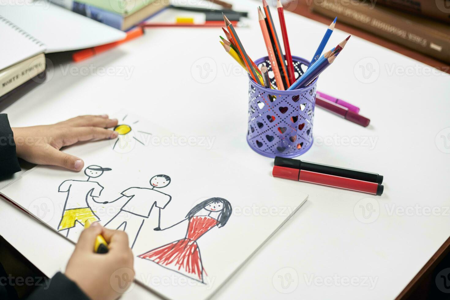 Family therapy. Schoolboy drawing family. Painting with colored marker photo