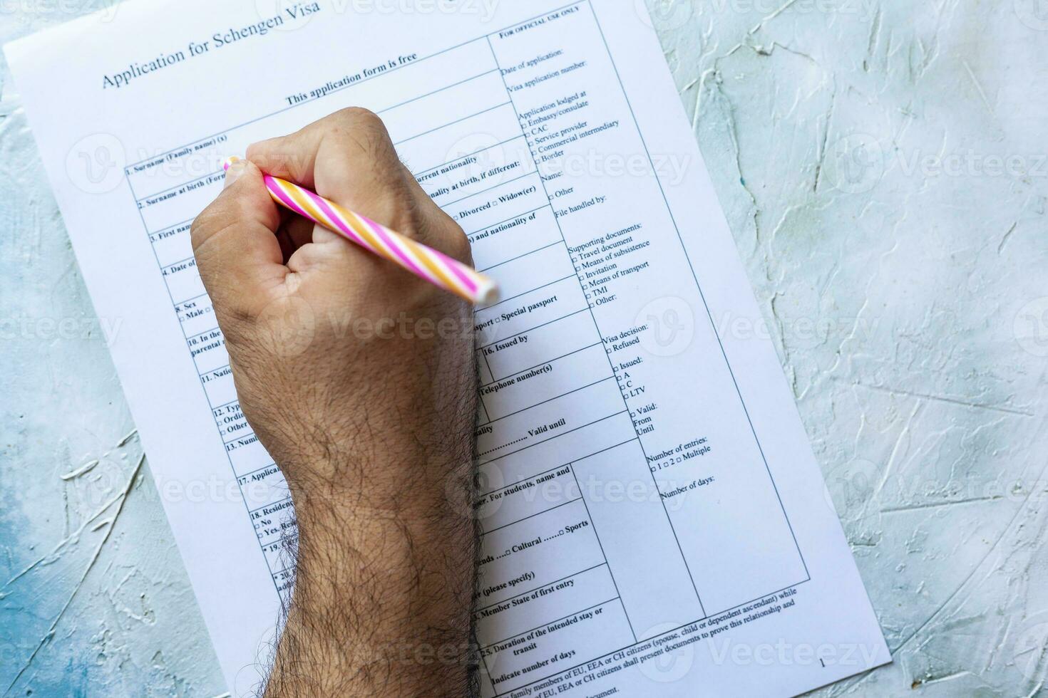 Hand filling Schengen Visa Application Form photo