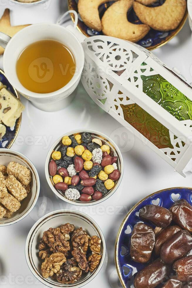 Iftar foods on white table. Traditional middle-eastern lunch with cookies and sweets photo