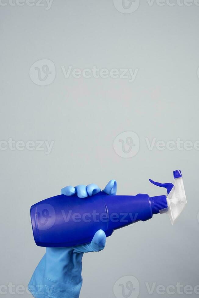 Female hand in rubber gloves holding disinfectant spray photo