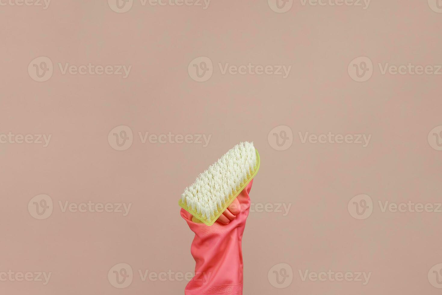 Female hand rubber glove holding scrub brush photo