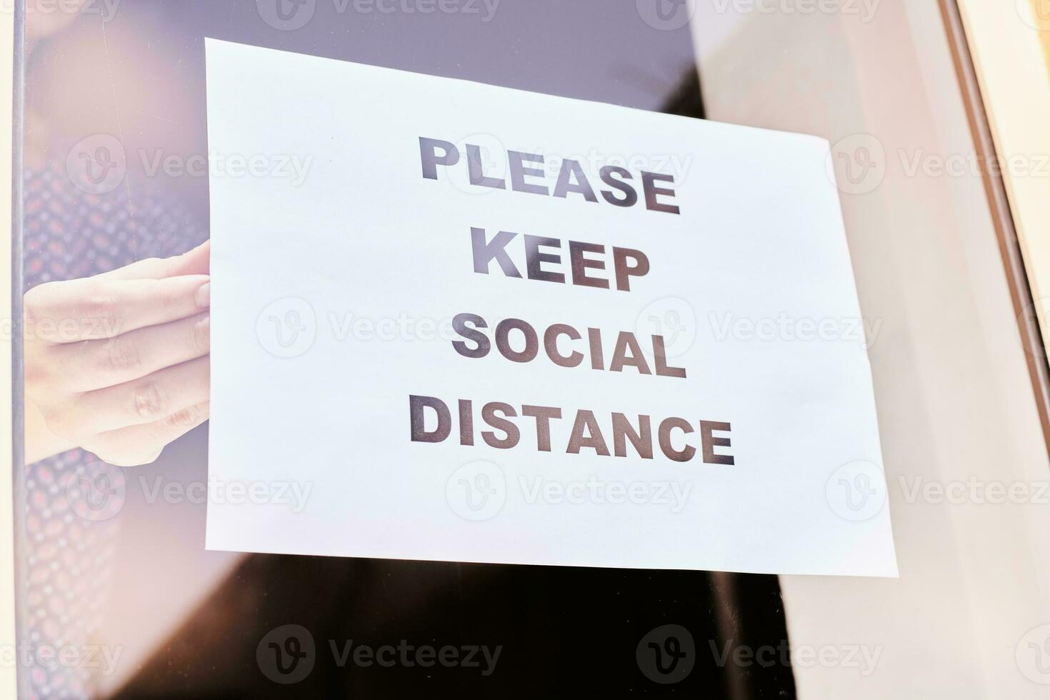 Shop or restaurant worker hanging a warning sign photo