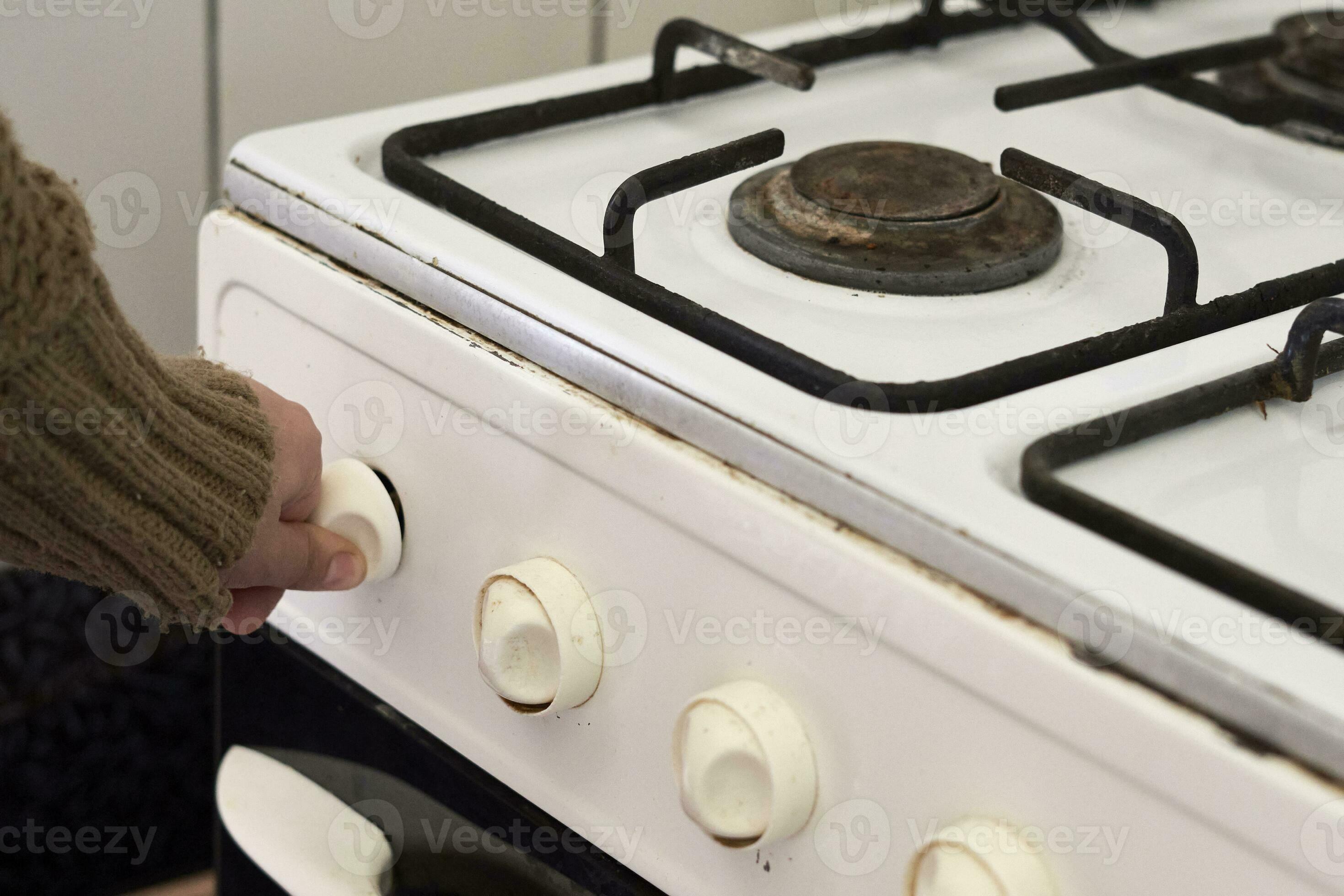 Woman checking gas, trying to turn on gas on old gas stove 31172361