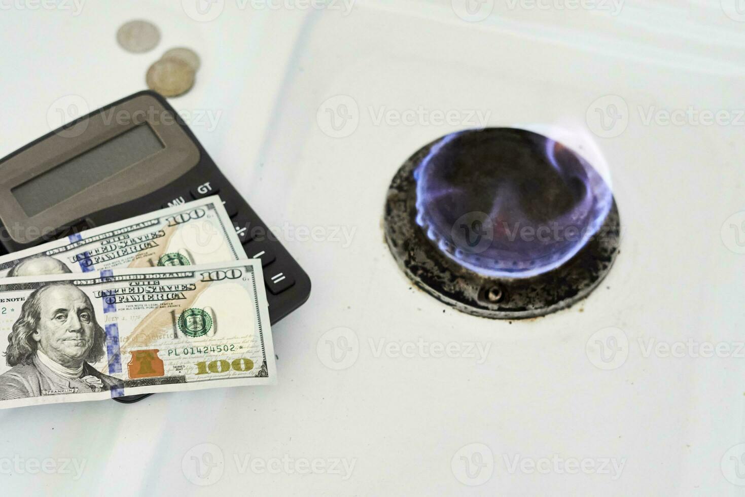 Burning gas stove burner, calculator and money photo