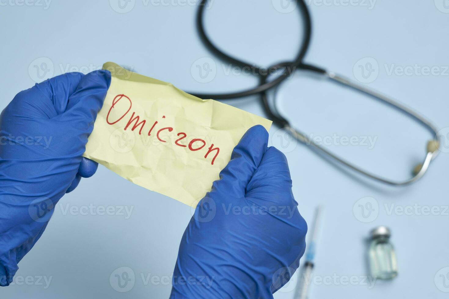 Doctor hand holds a piece of rumpled paper with Omicron text photo