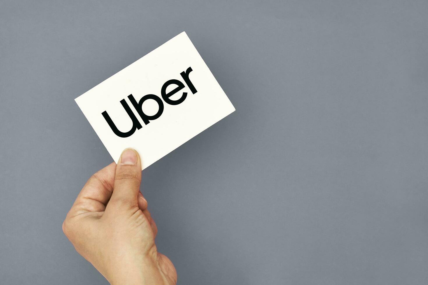 Hand holds a card with Uber logo photo