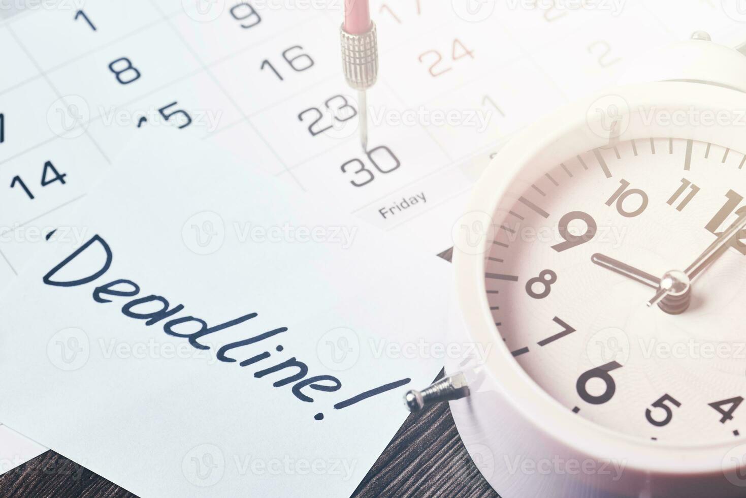 Deadline text on piece of paper, alarm clock and monthly calendar photo