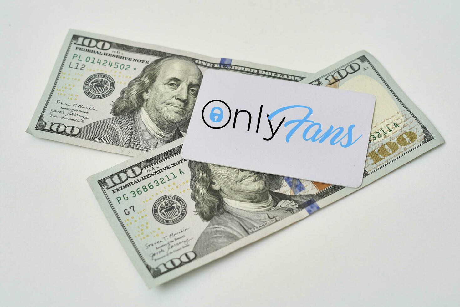 Pile of us dollars and Onlyfans card photo