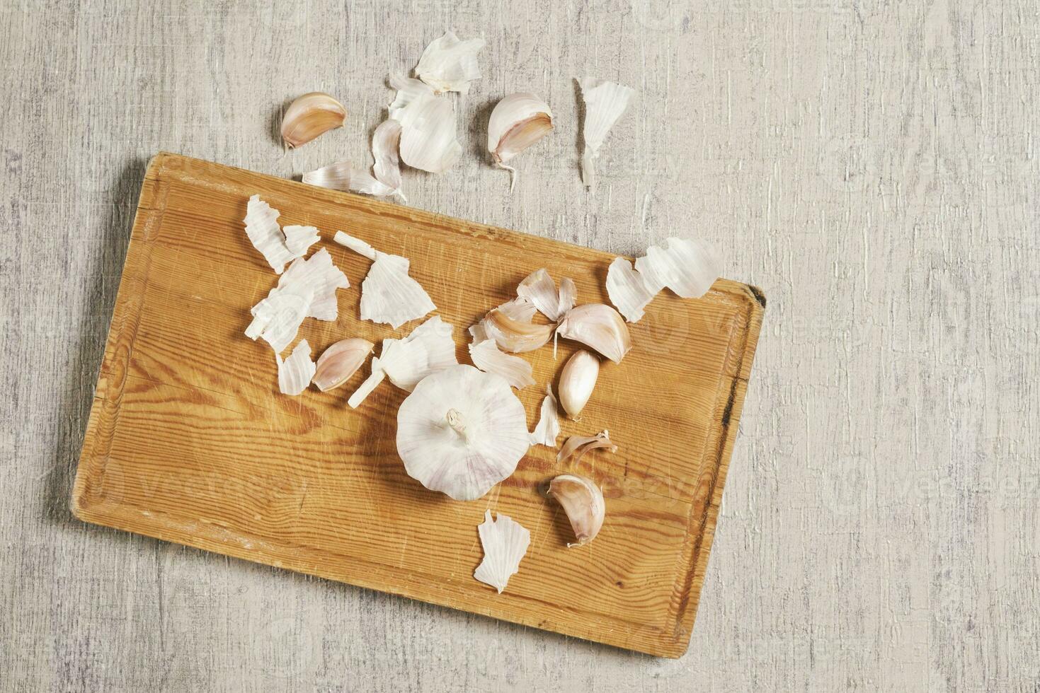 Cleaning organic garlic on cutting board photo