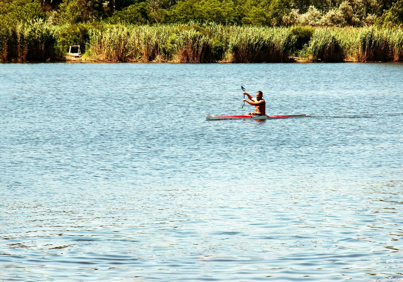 Dnipro, Ukraine - 06.20.2023 Technique of rowing of a single athlete on a kayak. Paddle splash motion. photo