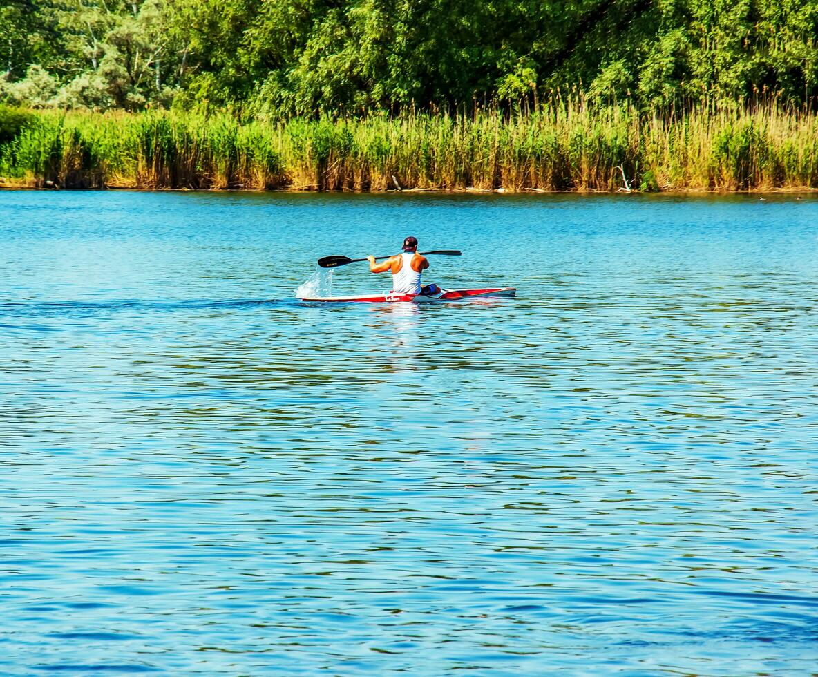 Dnipro, Ukraine - 06.20.2023 Technique of rowing of a single athlete on a kayak. Paddle splash motion. photo