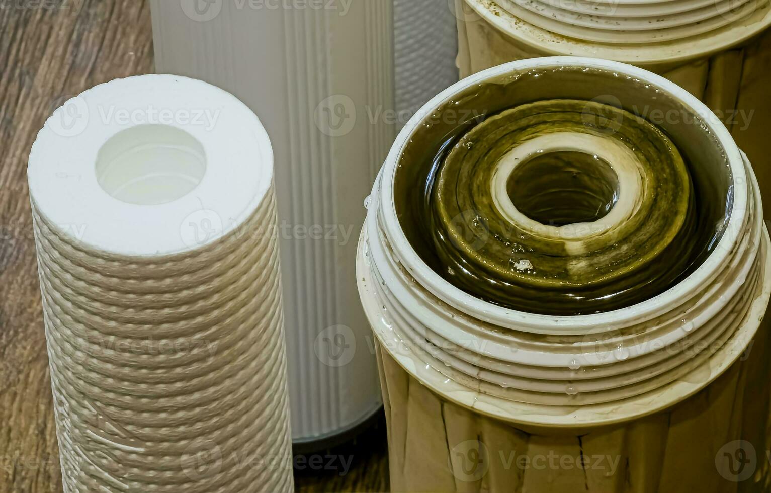 Used water filters with traces of dirt, clay and impurities and clean filters, prepared for replacement. Replacing multi-stage water filter cartridges. photo