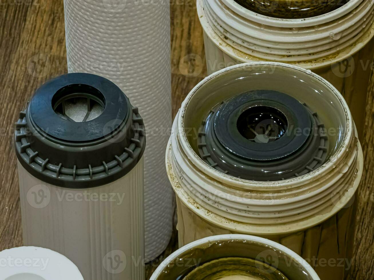 Used water filters with traces of dirt, clay and impurities and clean filters, prepared for replacement. Replacing multi-stage water filter cartridges. photo