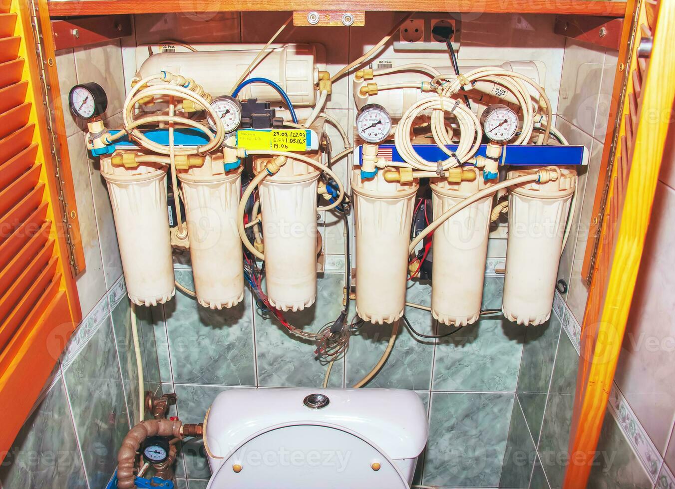 The system of purification of tap water in the apartment. The process of replacing the cartridges of a multi-stage water filter. photo