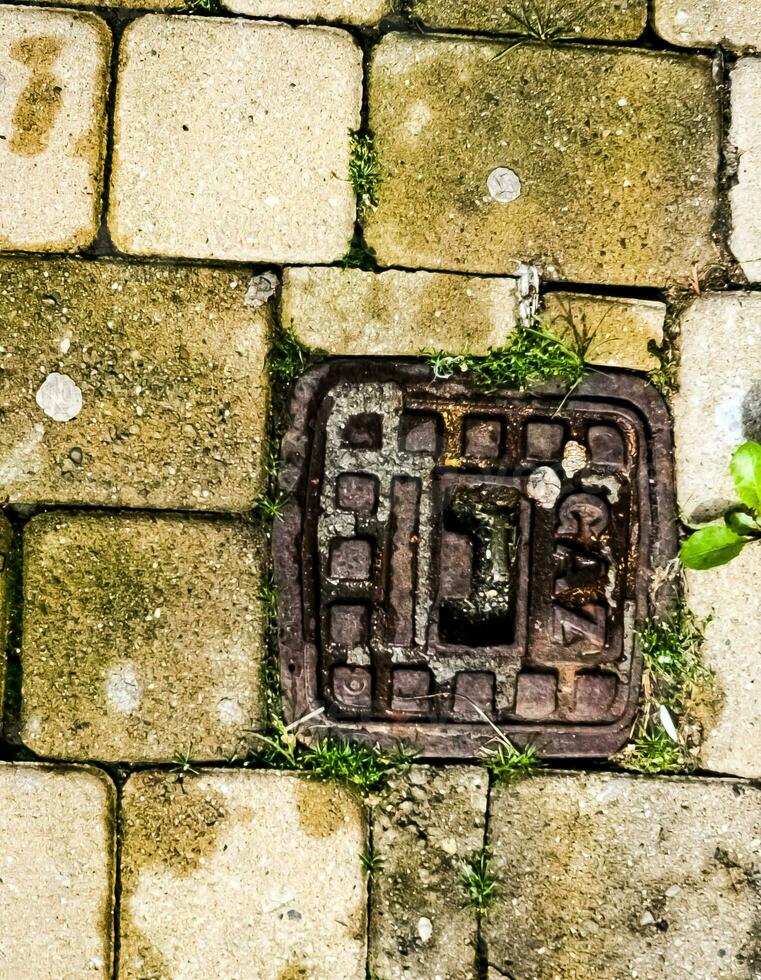 tapa de alcantarilla del sistema de gasoductos. una escotilla metálica masiva para el acceso a las comunicaciones de la ciudad en el pavimento. foto