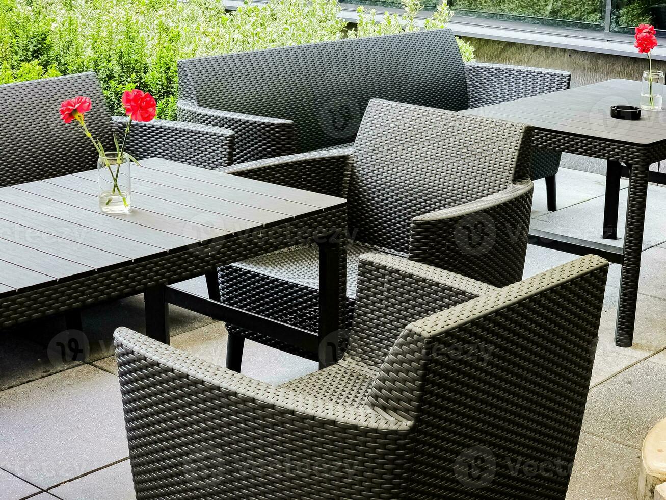 Table and chairs on an outdoor patio after the rain. There are no people in the cozy bar. photo