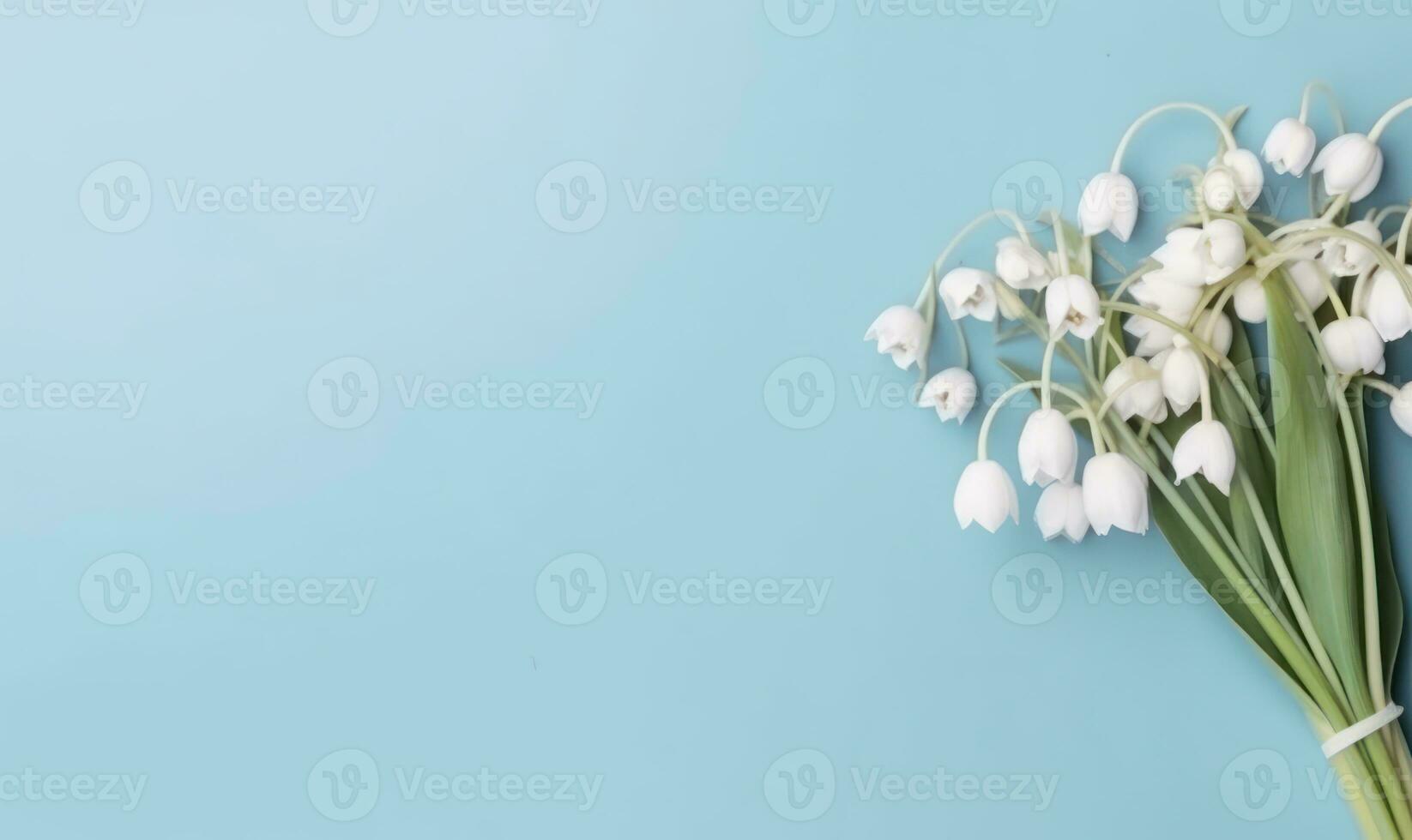 A snowdrop flowers bouquet on a pastel blue background with empty copyspace. Mother's Day concept. Created by generative AI photo