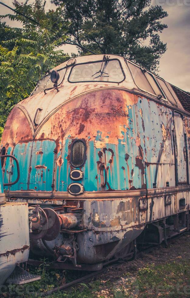 Rusty locomotive - left on abandoned train tracks photo