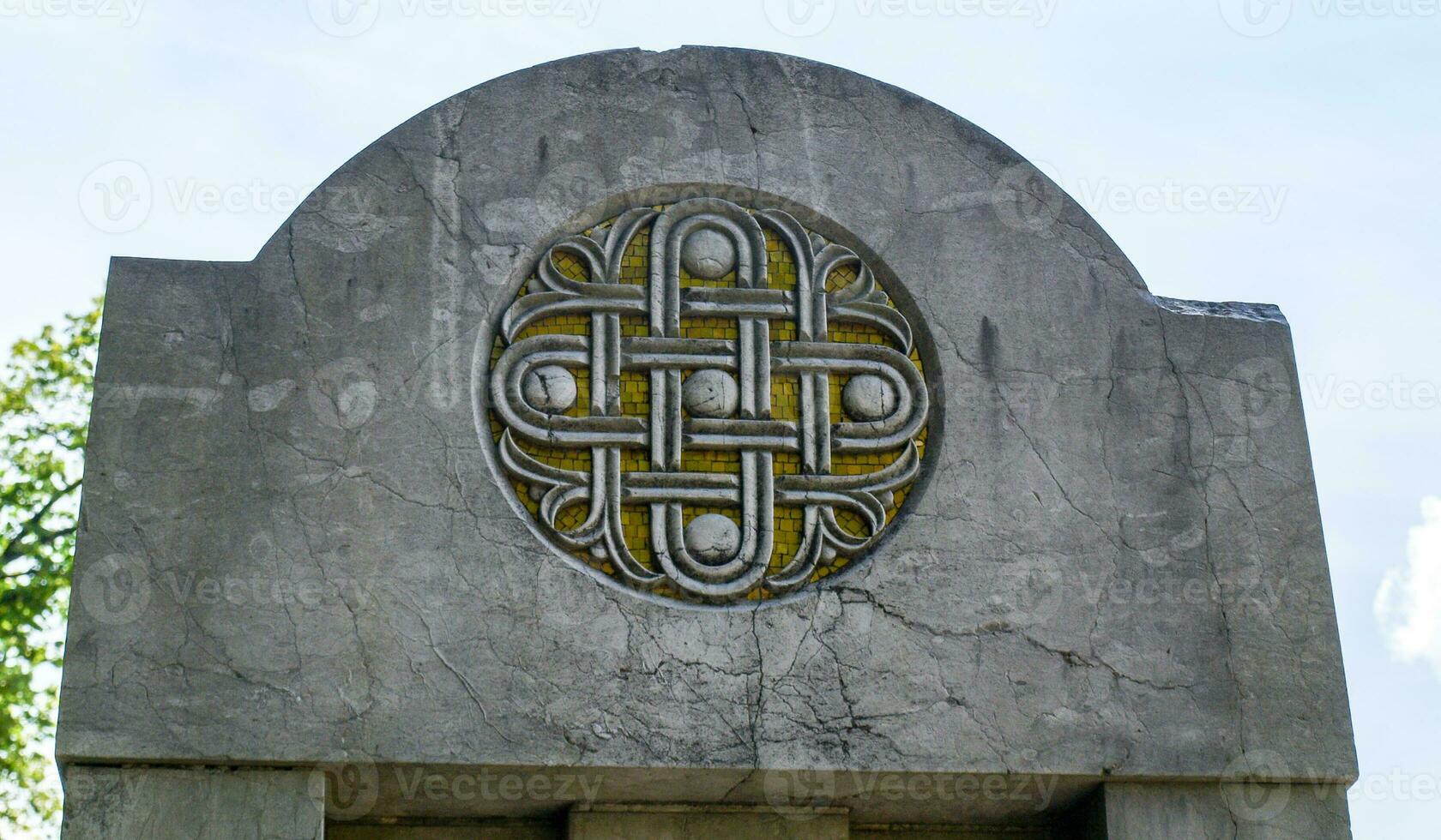 Fine circular stone symbol on yellow stone mosaic photo