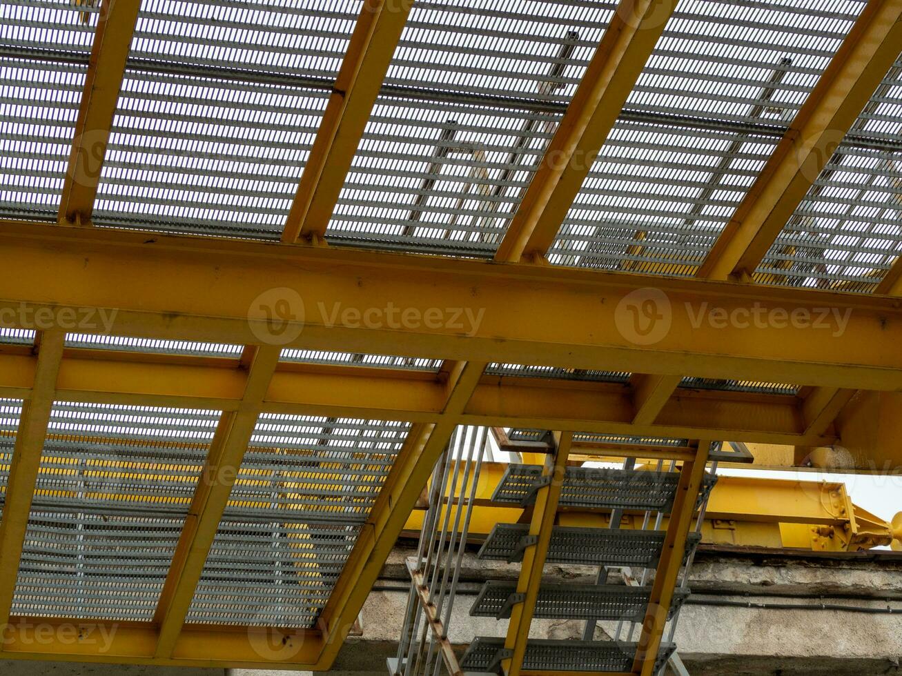 Yellow grid construction floor with stairs going up - shot from below photo