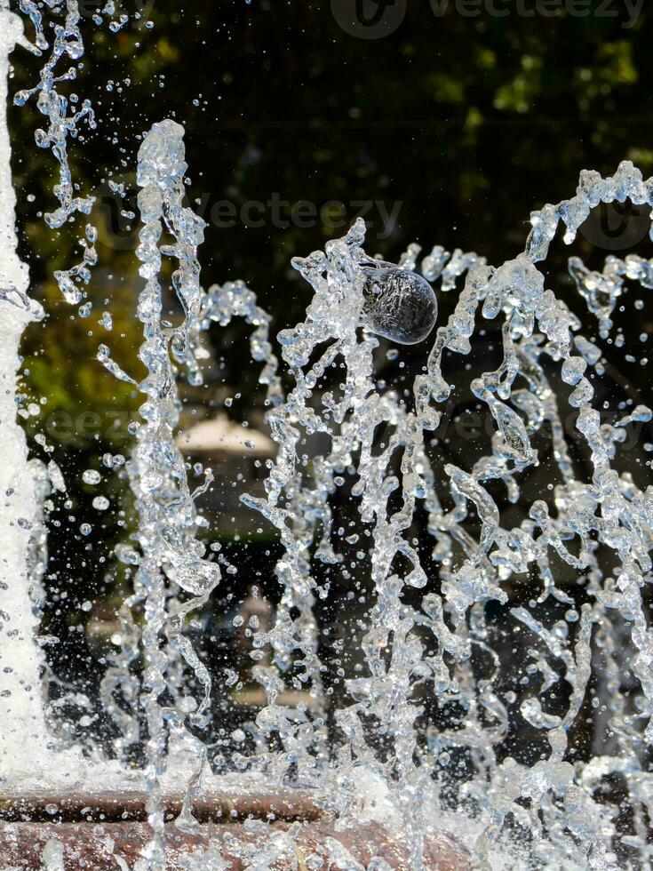 Water fountain - closeup shot on water flows and droplets photo