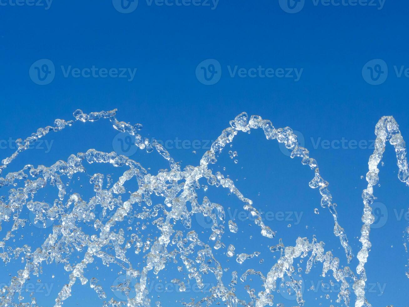 Water dropolets and streams - blue sky background photo