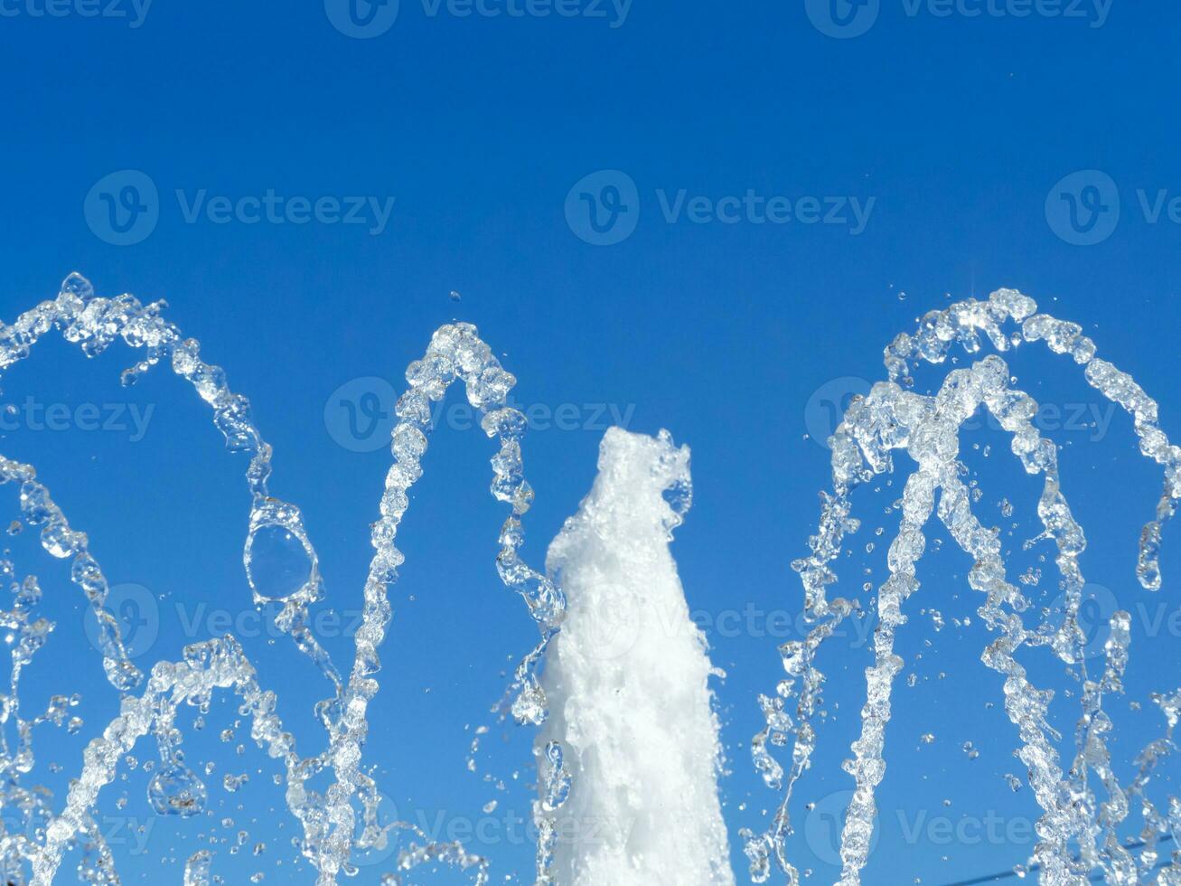 Fountain water streams - blue sky background photo