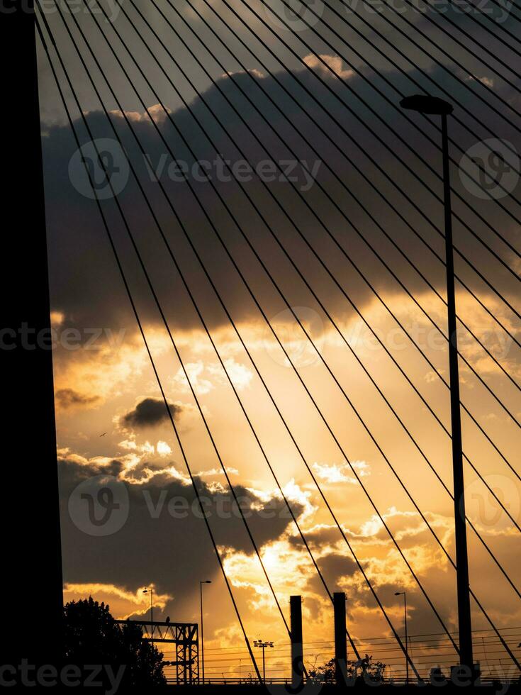 Highway, lightpost, chimney bridge silhouettes at sunset photo