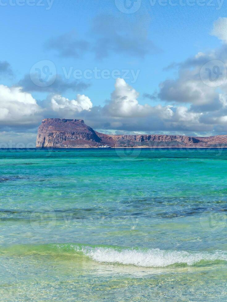 Amazing clear blue water on Balos beach - Gramvousa fortress on the horizon photo