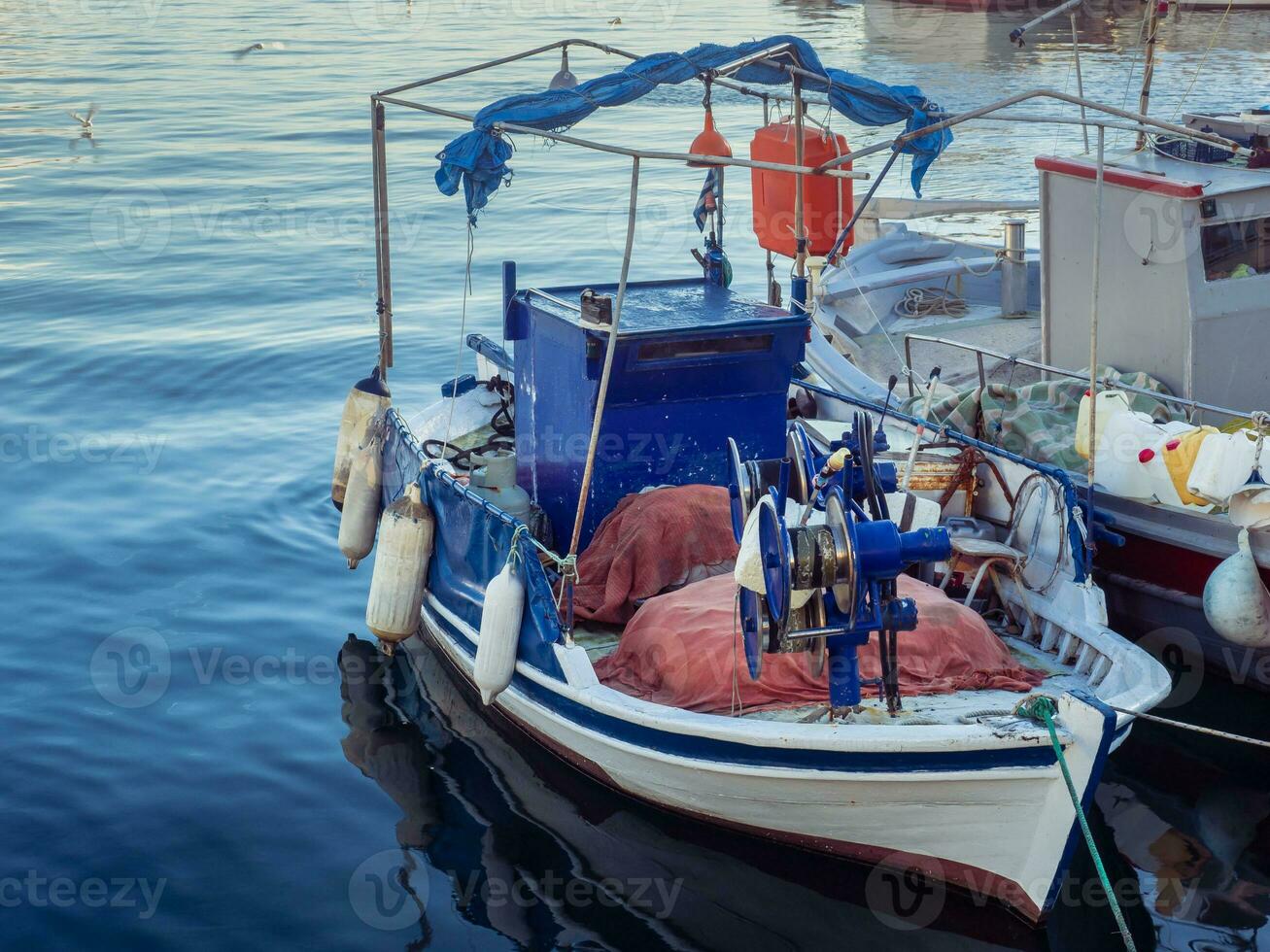 Small fishing boat tied to the dock photo