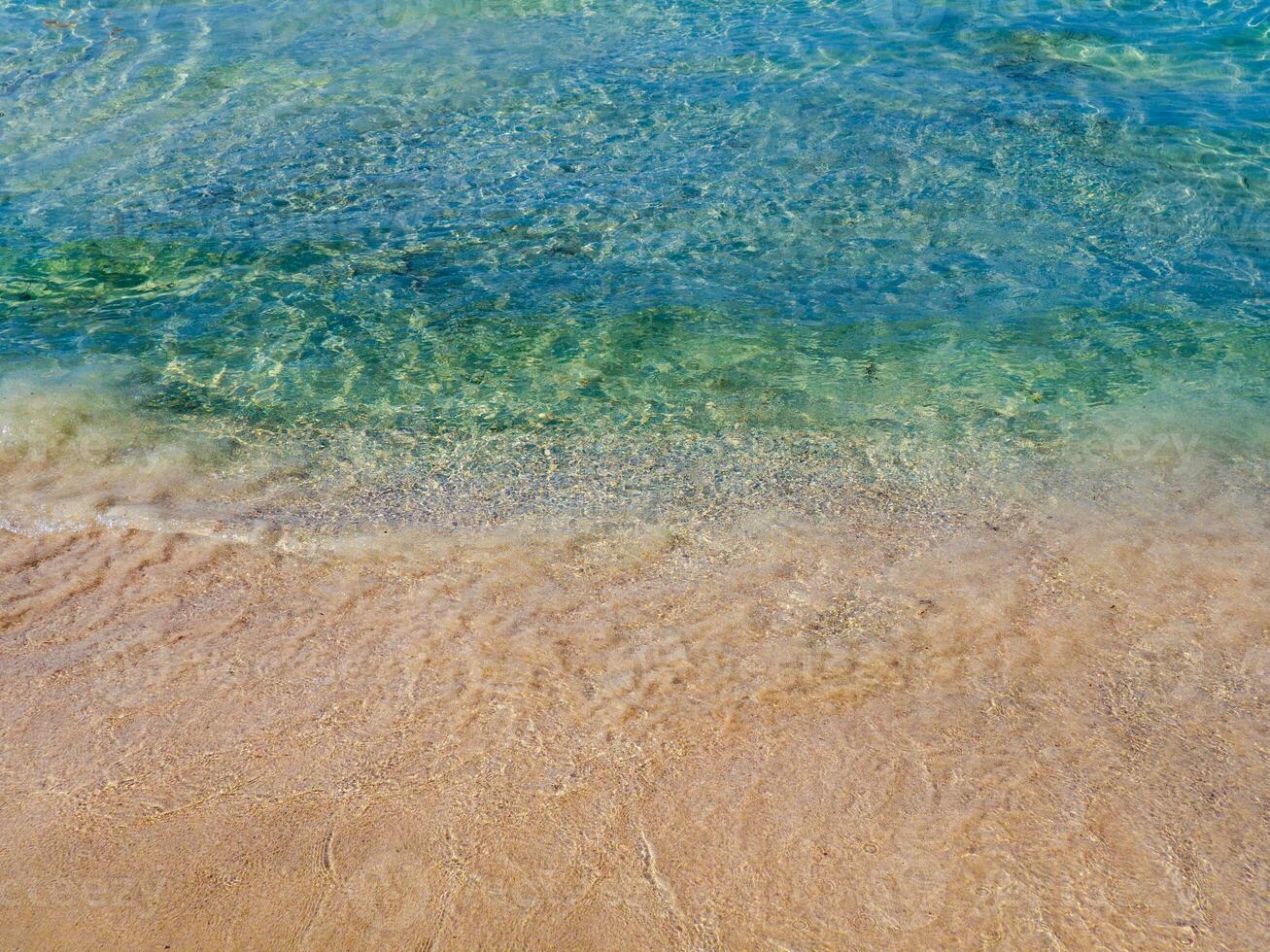 Orange sands and crystal clear blue water - empty beach in Crete, Greece photo