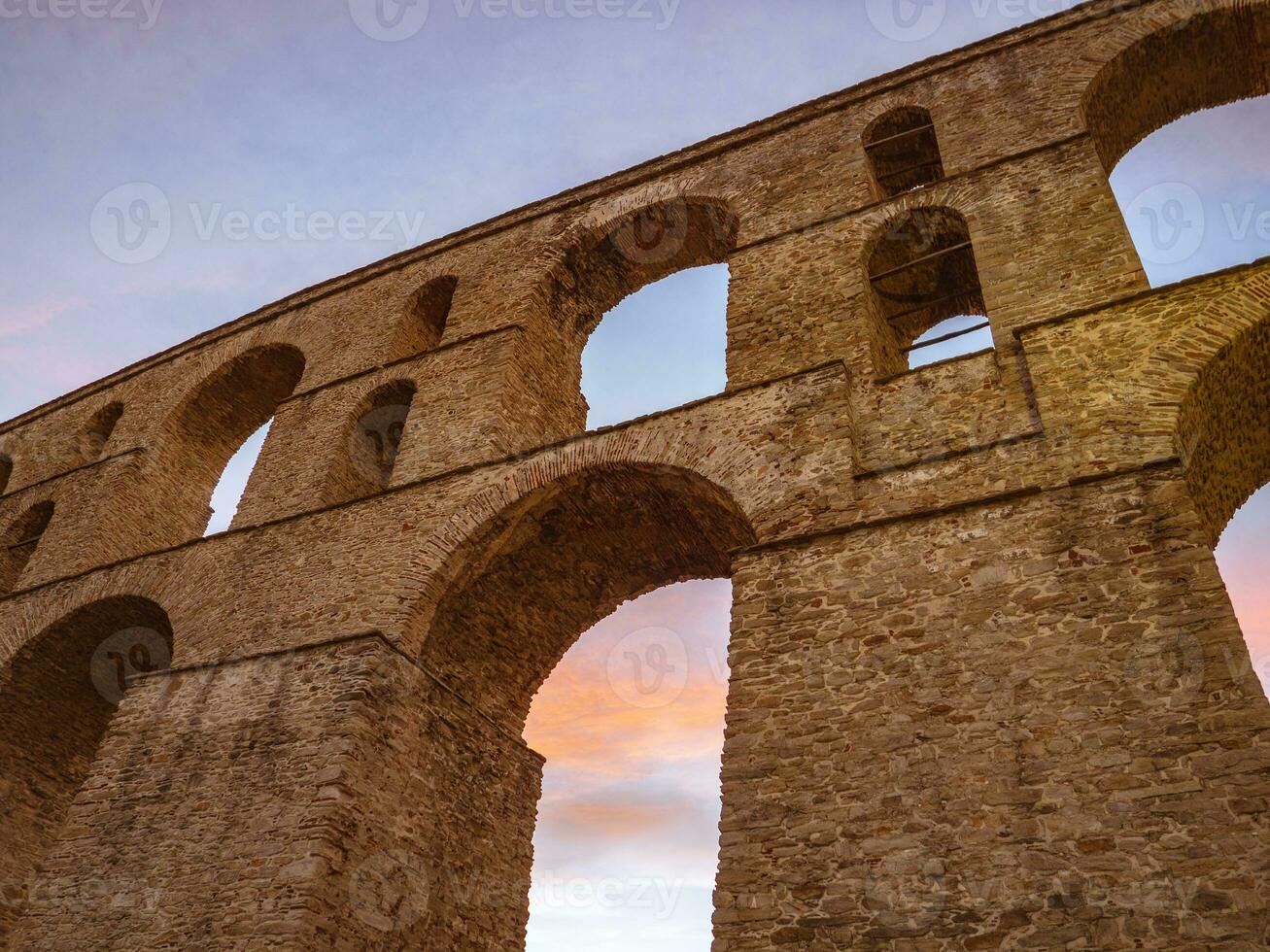 Ancient Roman architecture - brick aqueduct - low angle sunset shot photo