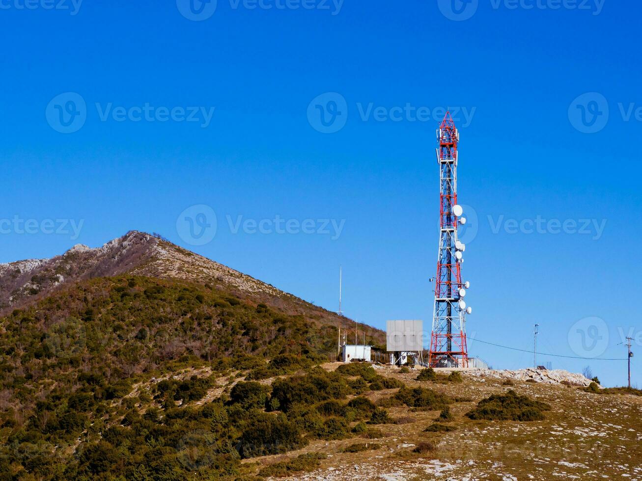 rojo y blanco antena torre en parte superior de el montaña foto