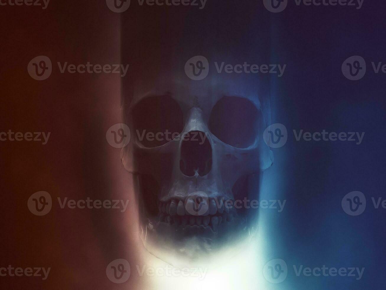 Skull in red and blue smoke with light shining from below photo