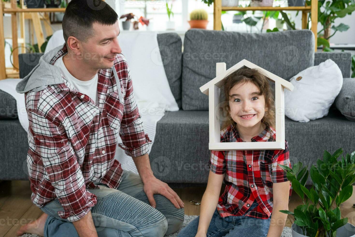 incompleto familia papá y hija son disfrutando nuevo hogar, sentado en sofá. hipoteca, seguro y proteccion, comprando y Moviente dentro tu propio hogar, verde casa con en conserva planta foto